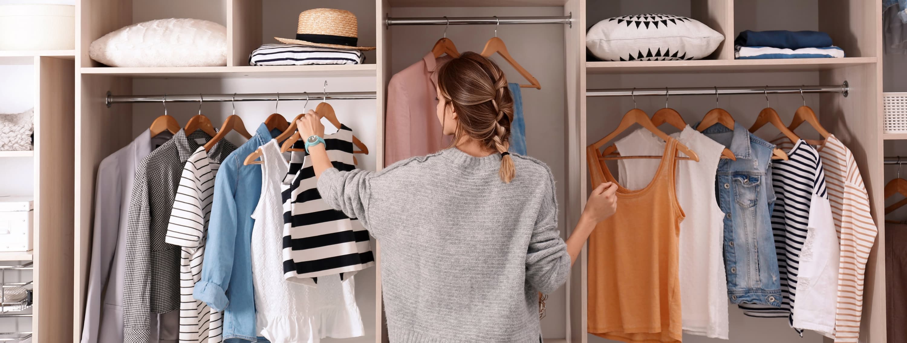 vrouw doet kleding in kast